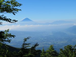 薄く雲海が広がる甲府盆地の上に富士山のシルエット