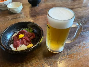 馬刺しをおつまみに生ビールで喉を潤す